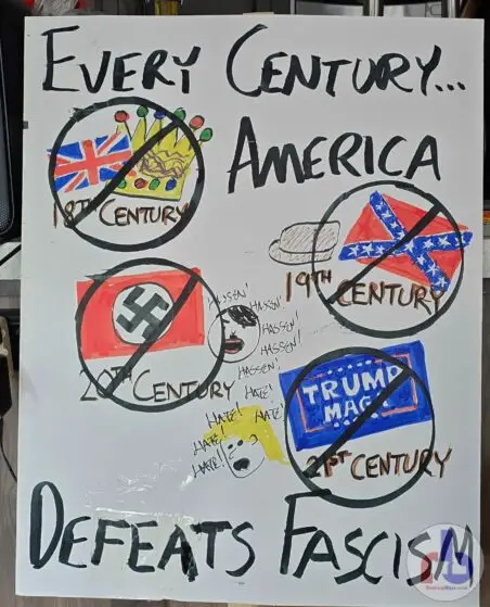 Russ's protest sign that reads "Every Century America Defeats Fascism" and cartoon cross-outs of 18th century Britain, 19th century Confederates, 20th century Nazis, and 21st century Trump MAGA.