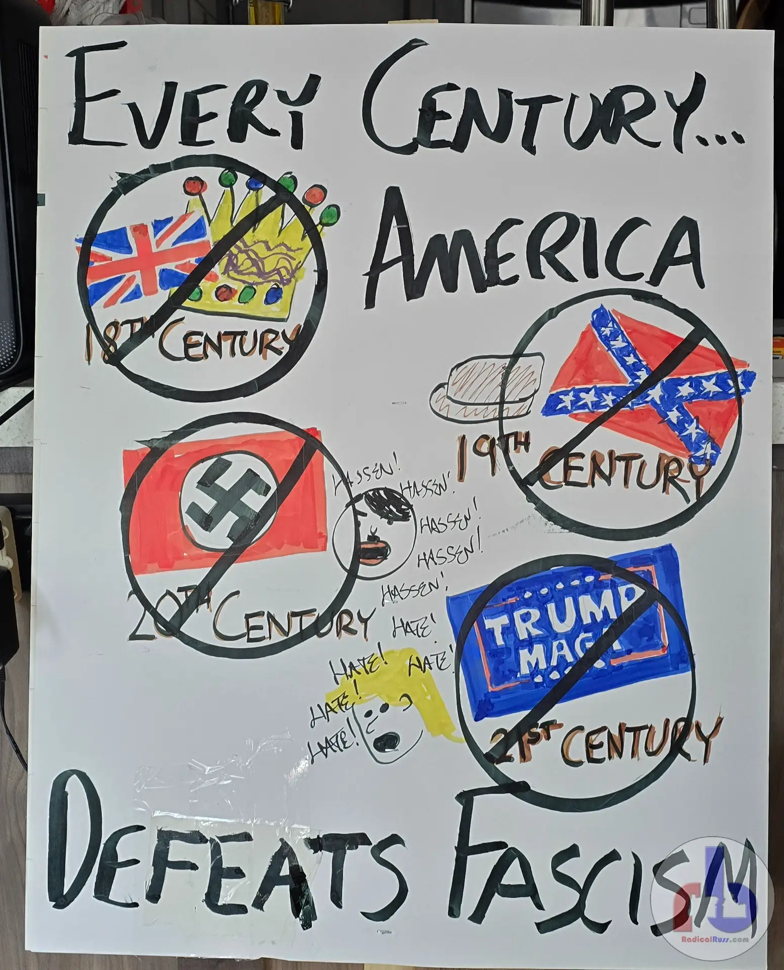 Russ's protest sign that reads "Every Century America Defeats Fascism" and cartoon cross-outs of 18th century Britain, 19th century Confederates, 20th century Nazis, and 21st century Trump MAGA.