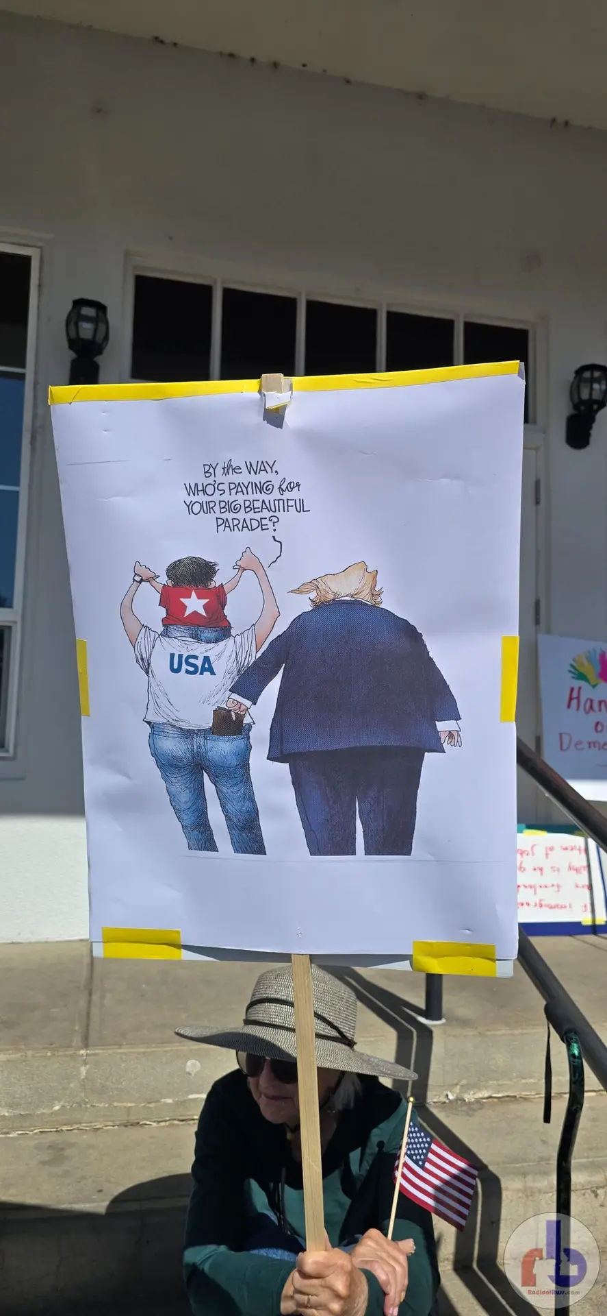 Cartoon of man with kid on his shoulder asking "By the way, who's paying for your big beautiful parade?" as Trump picks his pocket.